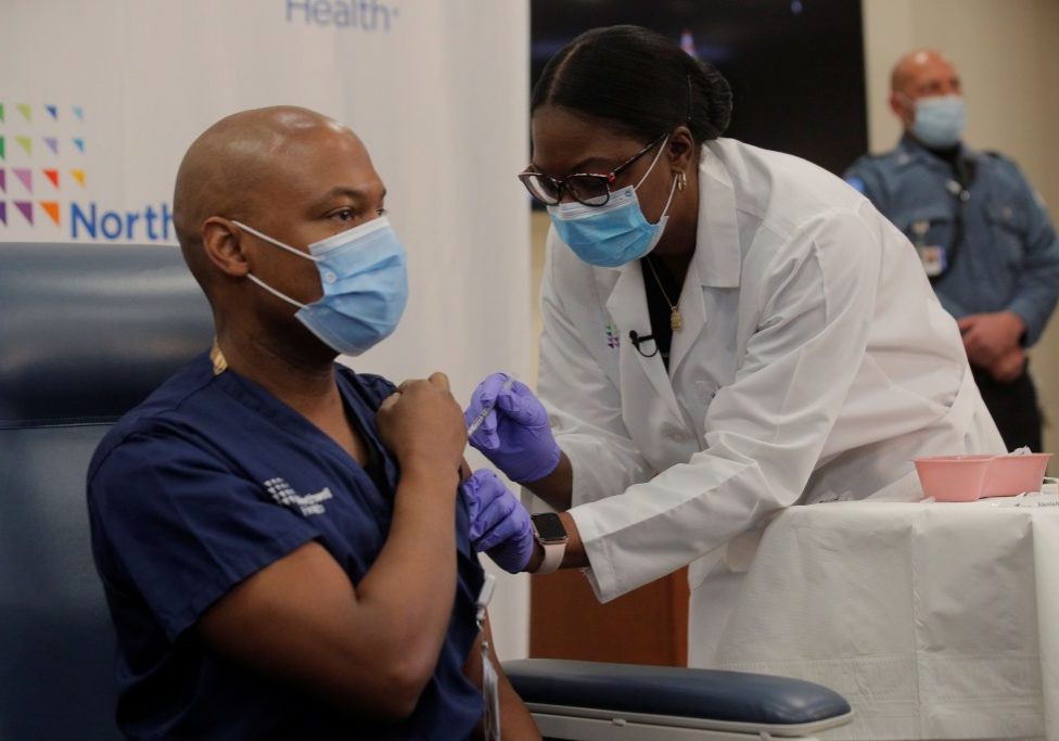 Health Care workers from Northwell Health receive the Pfizer COVID-19 vaccine Dr Yves Duroseau from Lennox Hill Hospital is inoculated with the coronavirus disease (COVID-19) vaccine by Dr. Michelle Chester from Northwell Health at Long Island Jewish Medical Center in New Hyde Park, New York, U.S., December 14, 2020. REUTERS/Brendan Mcdermid