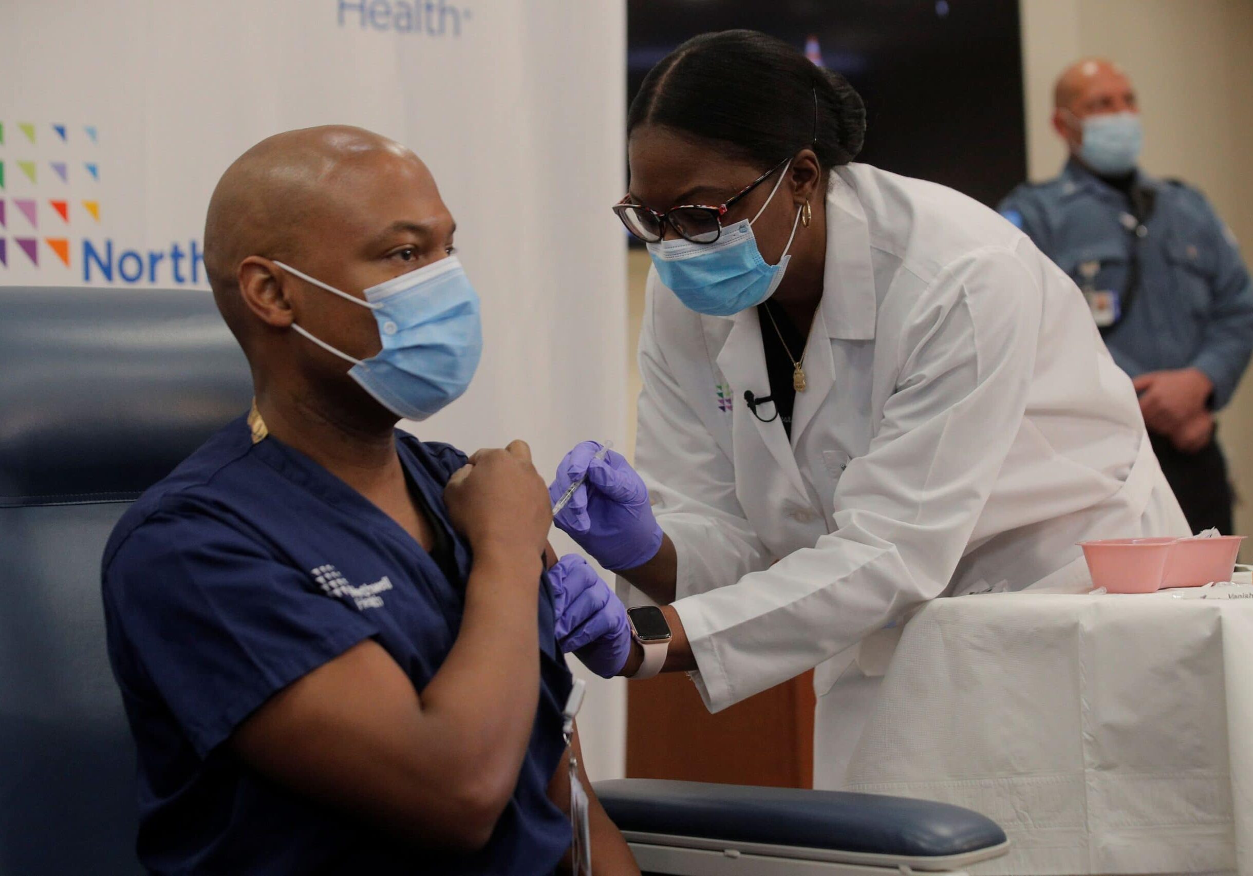 Dr Yves Duroseau from Lennox Hill Hospital is inoculated with the coronavirus disease (COVID-19) vaccine by Dr. Michelle Chester from Northwell Health at Long Island Jewish Medical Center in New Hyde Park, New York, U.S., December 14, 2020. REUTERS/Brendan Mcdermid