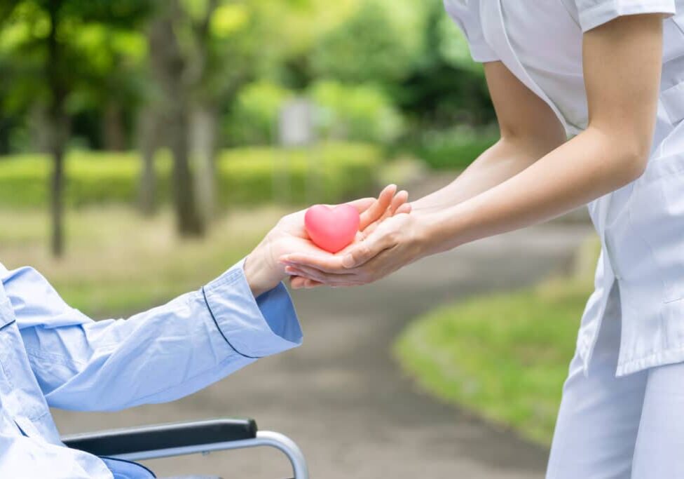 people holding heart symbol in park people holding heart symbol in park