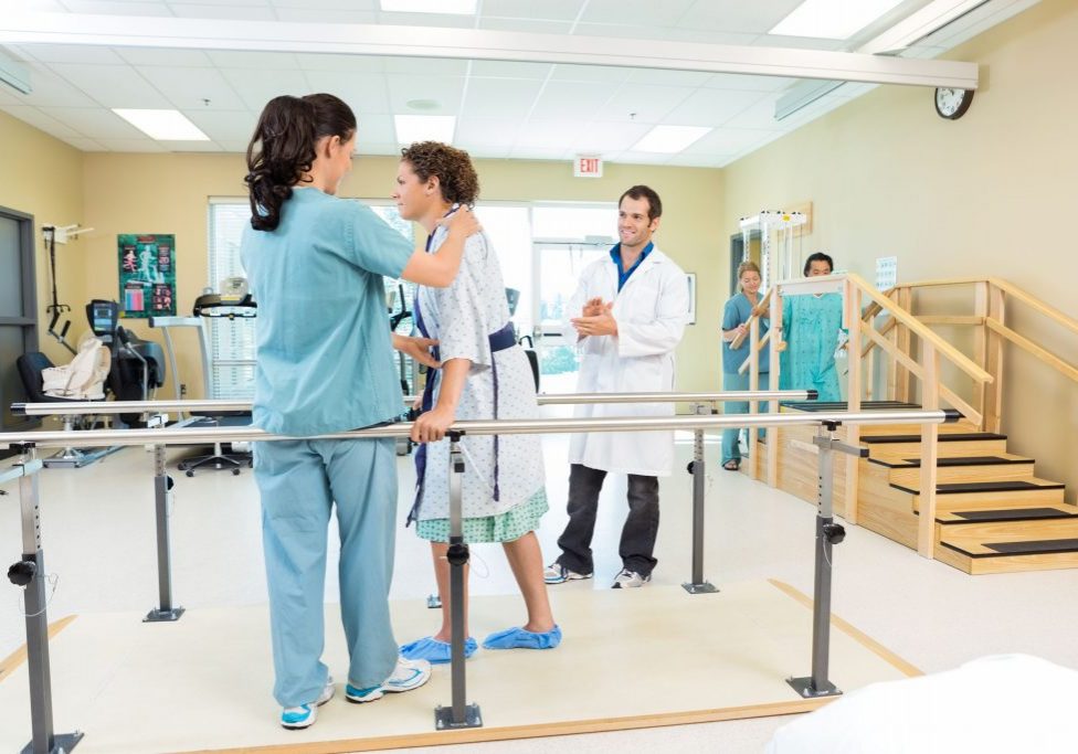 33558005 - physical therapist assisting patient in walking 33558005 - physical therapist assisting patient in walking